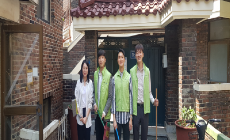 청소도구를 들고 미소짓는 봉사자들