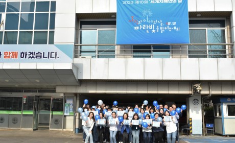 제16회 세계자폐인의 날 현수막과 복지관 직원 모습