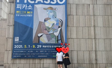 피카소 특별전 대형현수막을 배경으로 기념사진을 찍은 학생과 어머님