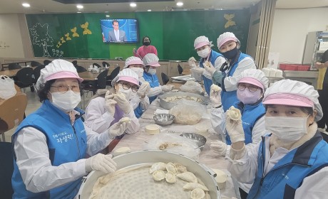 직접 빚은 만두를 들고 인증사진을 찍는 봉사단원들