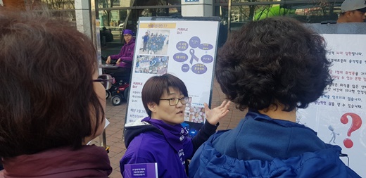 사람희망 금천장애인자립새활센터 정지영간사가 26일 퍼플데이 캠페인에서 지역주민에게 뇌전증장애인에 대해 설명하고 있다. 