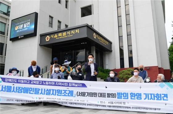 ▲ 더불어민주당 서윤기 서울시의원이 2022년 5월 20일 서울시의회 본관 앞에서 열린 ‘서울시 장애인 탈시설 지원조례 발의 환영 기자회견’에서 탈시설 조례안 발의 계획을 밝히고 있다. ⓒ에이블뉴스DB
