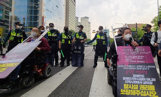 지난 18일 오전 아모레퍼시픽 본사 앞 횡단보도를 점거해 “추가경정예산에 장애인권리예산을 반영해달라”고 외치는 전국장애인차별철폐연대 긴급행동.ⓒ에이블뉴스DB