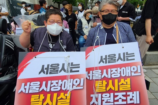 ▲ 16일 서울시의회 본관 앞에서 열린 탈시설 조례 제정 촉구 결의대회 모습. 이형숙 서울시장애인자립생활센터협의회 회장과 진형식 서울시장애인자립생활센터총연합회 회장.ⓒ에이블뉴스
